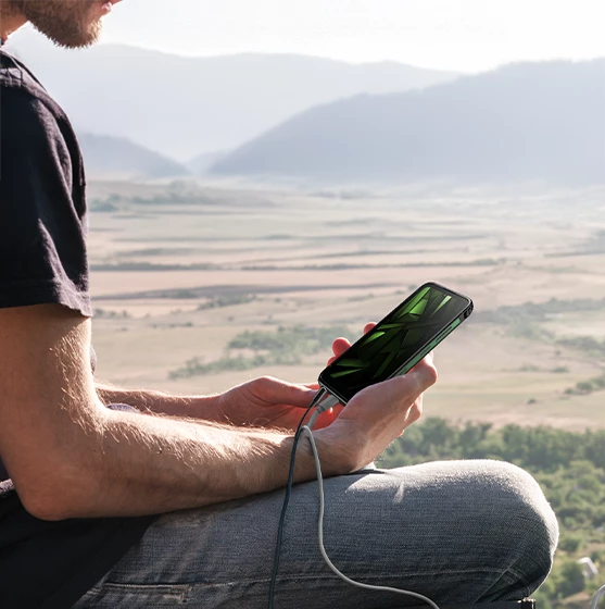 Mężczyzna słuchający muzyki na słuchawkach na HAMMER RANGER, w tle pola i góry