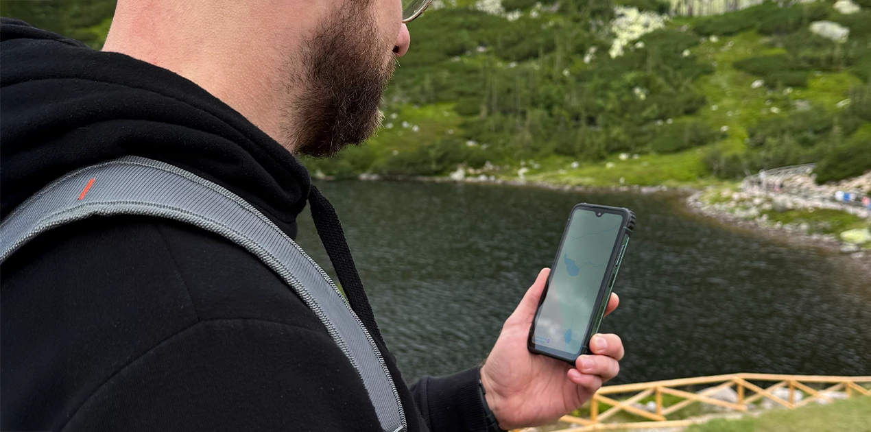 Mężczyzna na trekkingu w górach, sprawdzający mapę na HAMMER RANGER