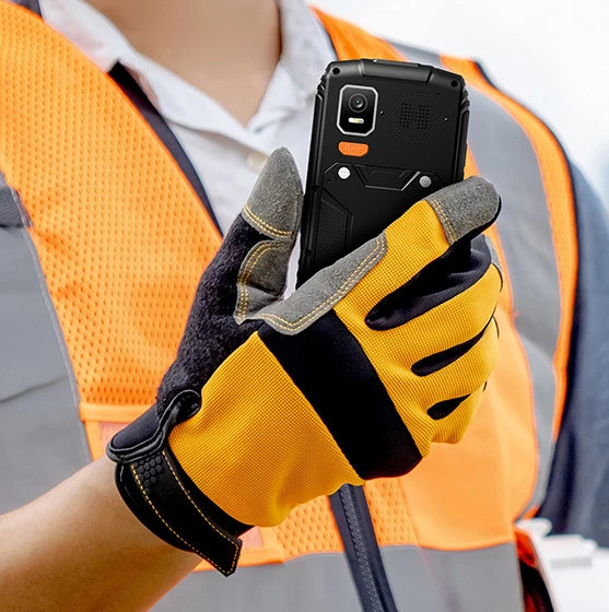 Pracownik budowy korzystający z telefonu HAMMER HORIZON LTE w rękawicach